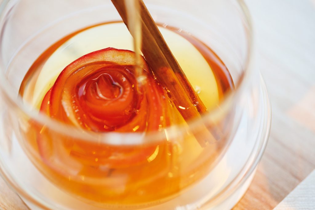 温かいアレンジティーのひとつ「アップルシナモン」420円。リンゴのスライスで作られたバラが、紅茶を注ぐと花開く。