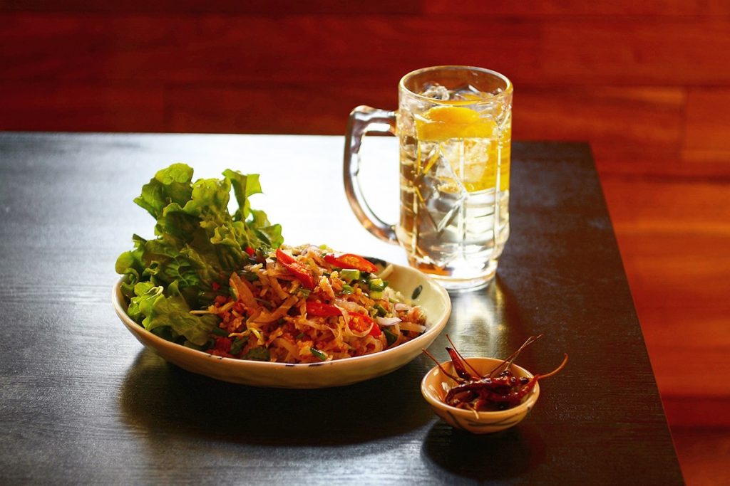 タイ風の発酵ソーセージと焼きおにぎりの辛いサラダ「ネームカオ」1,150円。これにはビールかハイボールがおすすめ。