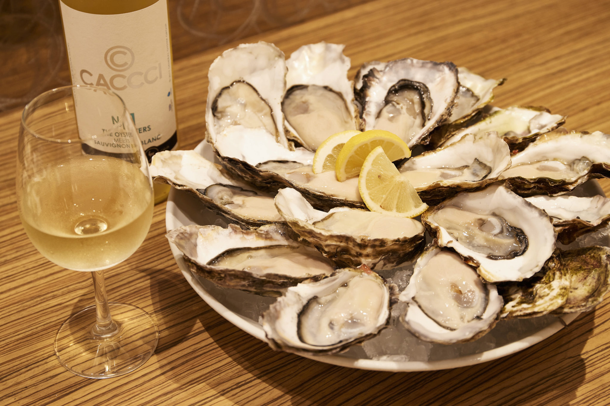 牡蠣に合うオリジナルの白ワイン、「CACCCI」グラス590円。