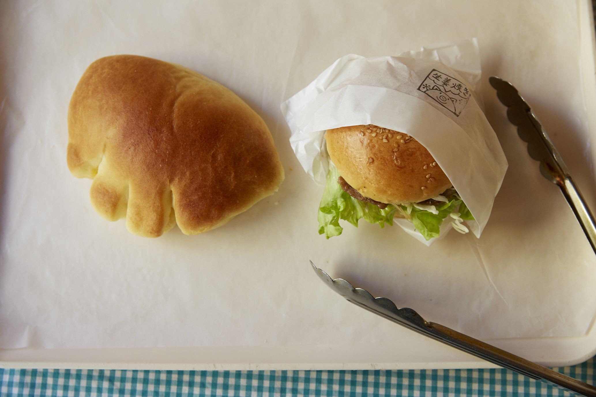 左が平日でも300個以上売れる「クリームパン」210円。右は「神楽坂バーガー 生姜焼き」310円。ほんのり甘いパンに、しょうゆ味の肉がよく合う。