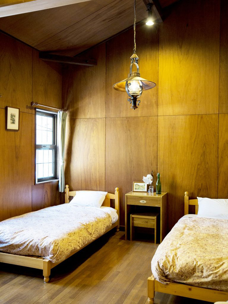 客室は2部屋あり1組6名ほどまで宿泊可。清々しく高い天井で、窓の外には益子の森が。