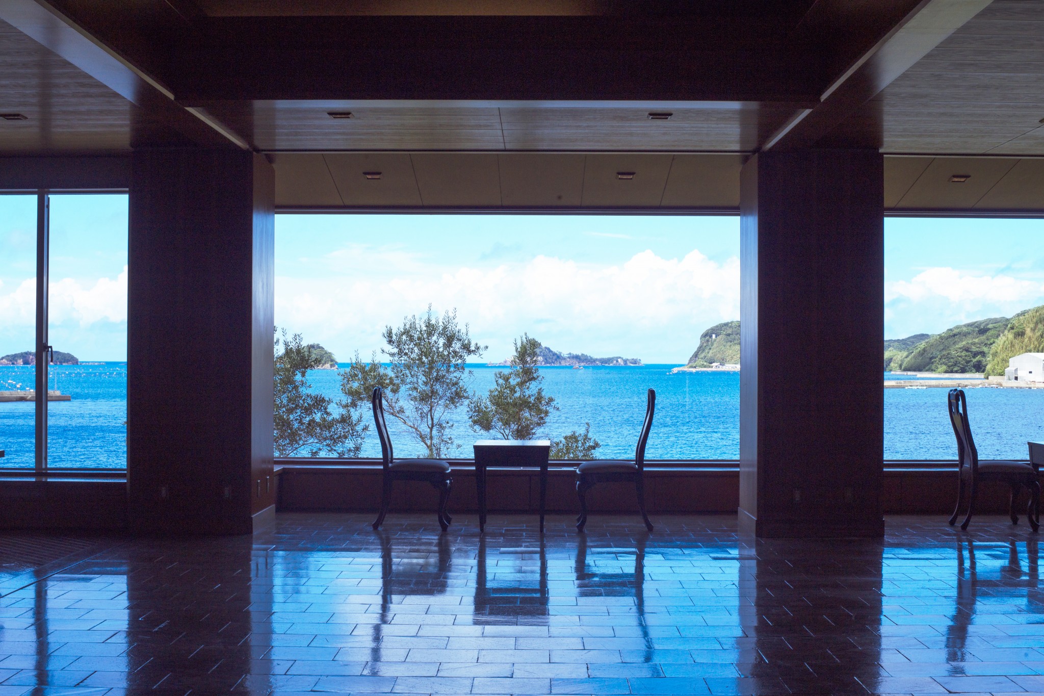エントランスのドアが開くと湯本湾が視界いっぱいに現れる。透明度の高い海や静かな漁村の風景を眺めるだけで心が澄み渡る。