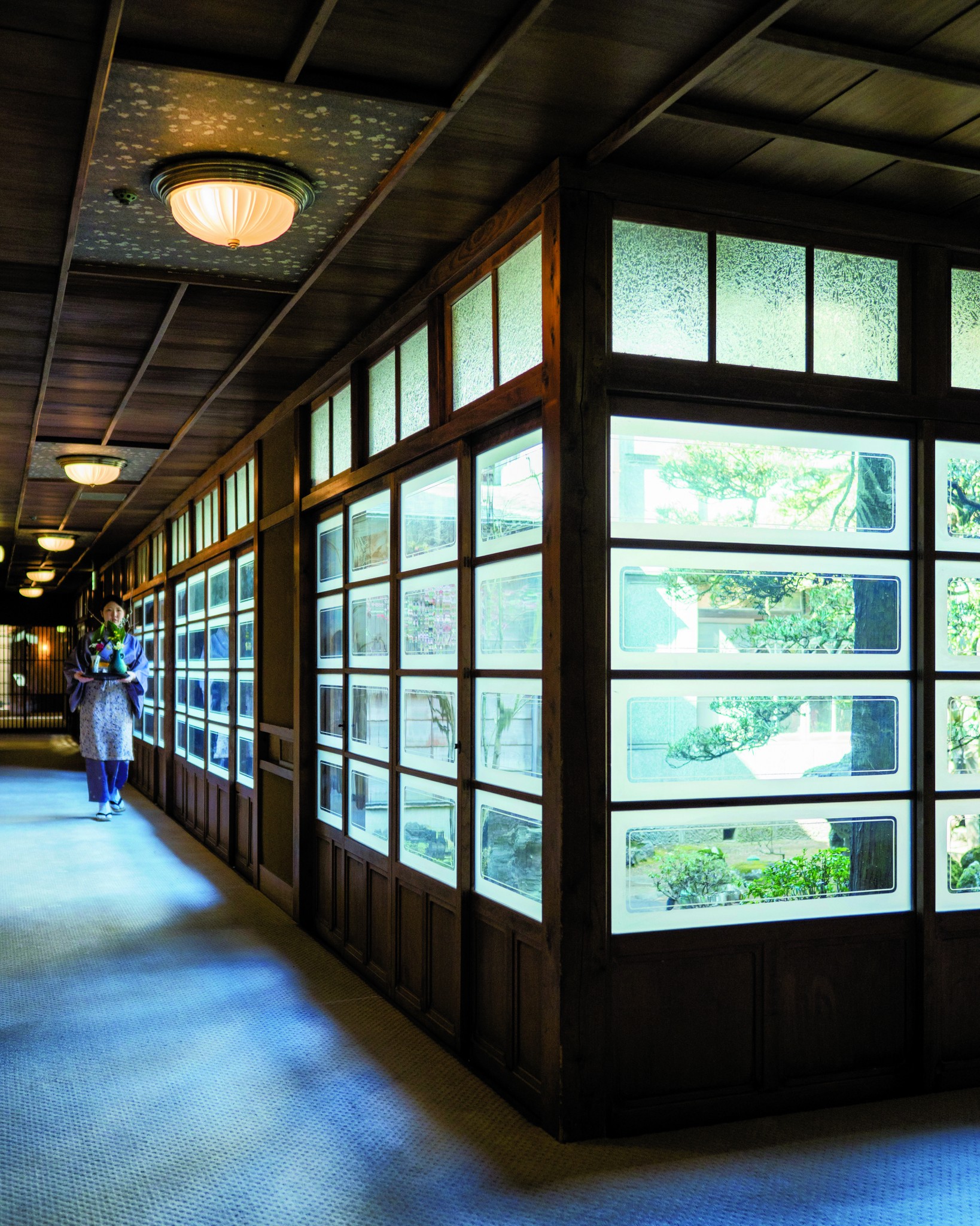 館内にある中庭のぐるりを囲む廊下。昭和初期の手仕事の、わずかに波打つガラス窓から覗く景色も、匠の意匠を今に伝える。
