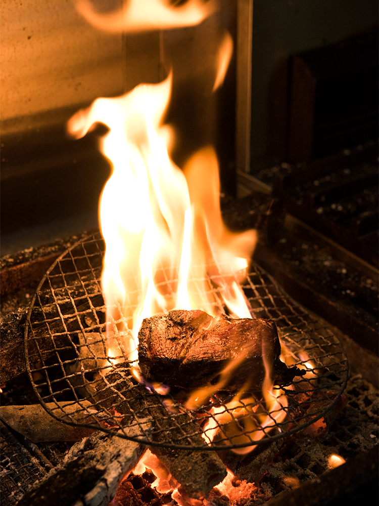 キッチンの炉で豪快に焼き上げる肉料理が評判。
