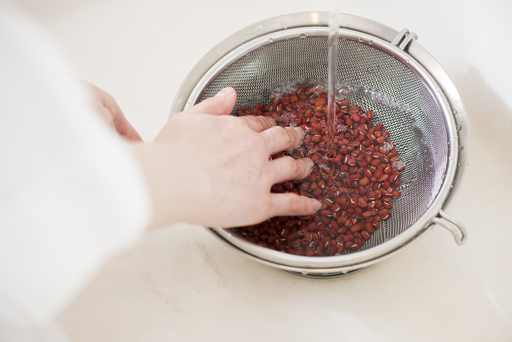 ざるとボールを使って小豆を洗う。