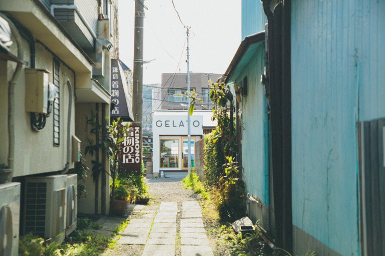 表通りからも目立つ白い外観。商店街の事務所だった所をリノベーション。裏手の小さなテラスには6席あって、江ノ電も見える。 鎌倉 GELATERIA SANTi