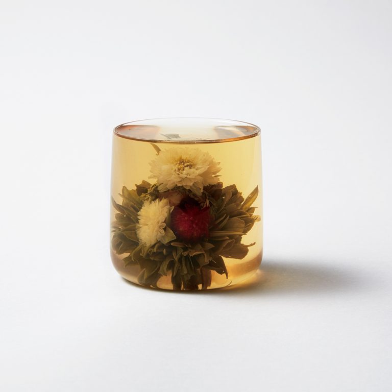 「花藍(はなかご)」860円。千日紅(せんにちこう)にバラ、金盞花(きんせんか)、貢菊と4種の花がふんだんに盛り込まれたお茶。お湯を注ぐ前は花籠の形で、そのままでもかわいらしい。お湯の中では花がひとまわり大きく膨らみ、貢菊は糸で繋がりふわりと浮き上がる仕掛け。美肌やリラックス、毒素排出、眼精疲労回復などの効果あり。大きく開くのでたっぷりとしたグラスやポットで。 653dc6adec16eb5aea74c751cf794cf0-768x768