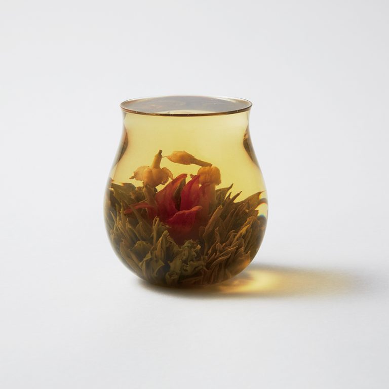 「康藝満球（こうげいまんきゅう）」520円。中国ではセレブに愛されるお茶だけあり、赤く大きな百合と白く小さなジャスミンの組み合わせが上品。お湯を注ぐ前は素朴なころんとした姿にもかかわらず、ここまで見事な花が開くと、驚きとともに華やかな気持ちにもなれる。百合にはビタミンやミネラルが豊富で美肌効果があるうえに、ジャスミンと一緒に飲むとリラックス効果も強くなるそう。