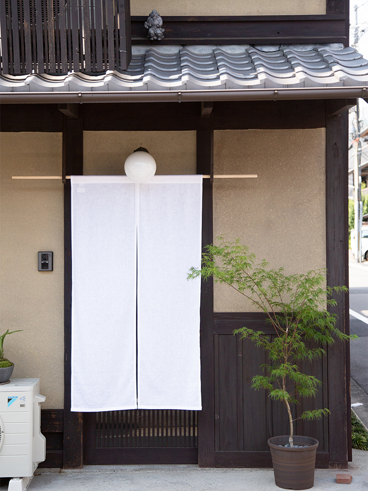 築100年という総2階の京町家の、1階部分。格子戸を開けると玄関があり、靴を脱いで入るスタイルも京都らしい。いちばん奥には小さな坪庭もある。