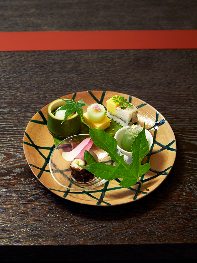 日本料理の伝統と美意識を守りつつ、のびのびと創意工夫を凝らす「五味自在」を標榜する料理長。器も自身の審美眼で選ぶ。鱧子豆腐など八寸が美しく盛られた皿は6代目高橋道八の写し。