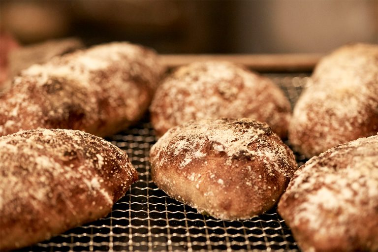 くるみクランベリー、ヨモギ大納言、カシューナッツ黒胡椒など色とりどりの個性的なパンが次々とオープンキッチン内で焼かれる。