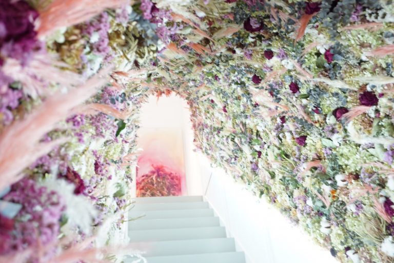 2Fのイートインスペースはこちらの階段から。ピンクをベースに鮮やかな花や植物が壁一面に彩られた、とっても可愛い階段です！