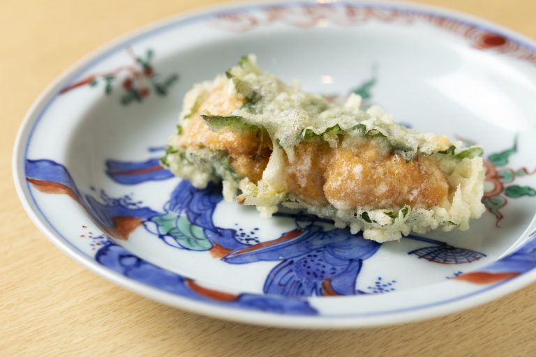 骨董好きの店主自らが選ぶ陶器にもこだわりが光る。美しい陶器のお皿と一品一品揚げたてが供される天ぷらの組み合わせは目にも楽しい。 てんぷら深町 京橋