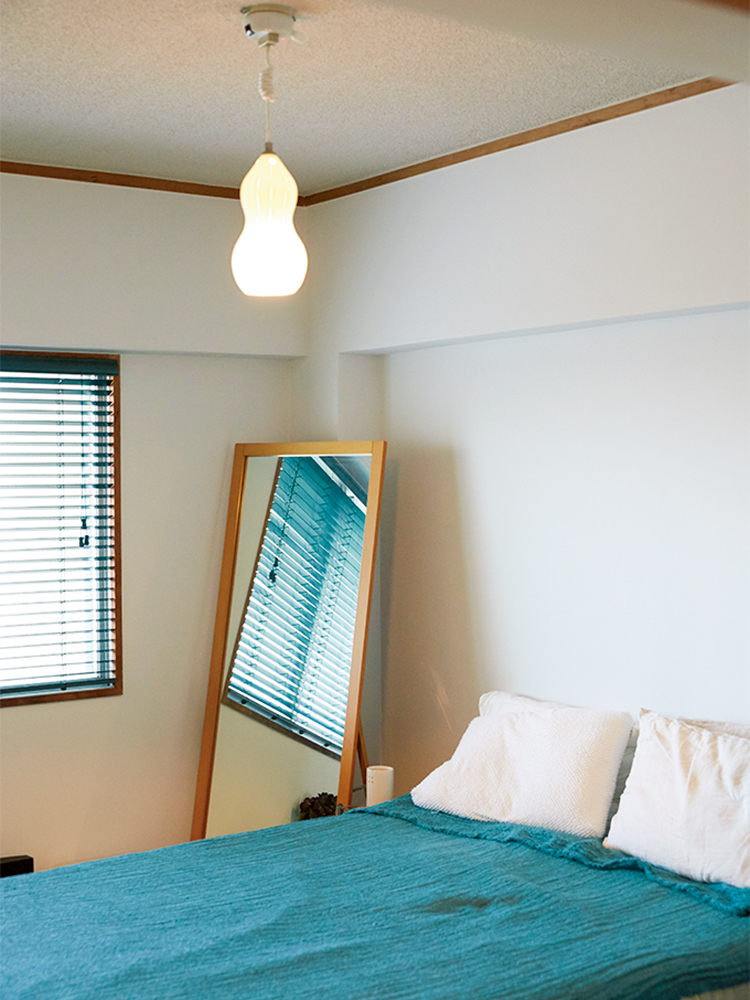 寝室のブラインドやベッドカバーはシックなグリーンで統一。