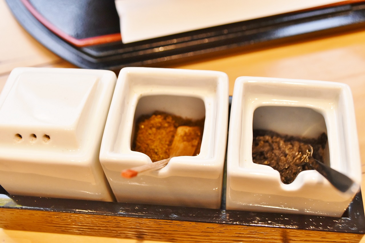 テーブルに置いてある薬味は左から、山椒、黒七味、塩昆布。そして小豆島の醤油もあります。