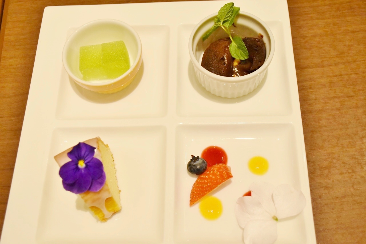 左上から、マスカット味の「パート・ド・フリュイ」、「フォンダンショコラ」、「ウィークエンドシトロン」、デザートを3つしかオーダーしない場合は、空いたスペースにフルーツとお花が添えられる。