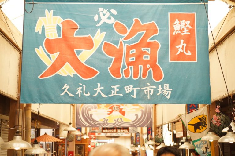 市場に掲げられた大漁旗。鮮魚店や直営の食堂が所狭しと並び、活気ムンムン！