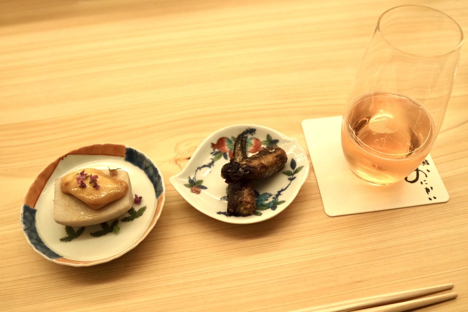 「里芋とモッツァレラチーズ」（左）と「ししゃも有馬煮」（中央）と〈フェラーリ〉のスパークリングワイン「マキシム ブリュット ロゼ」（右）。
