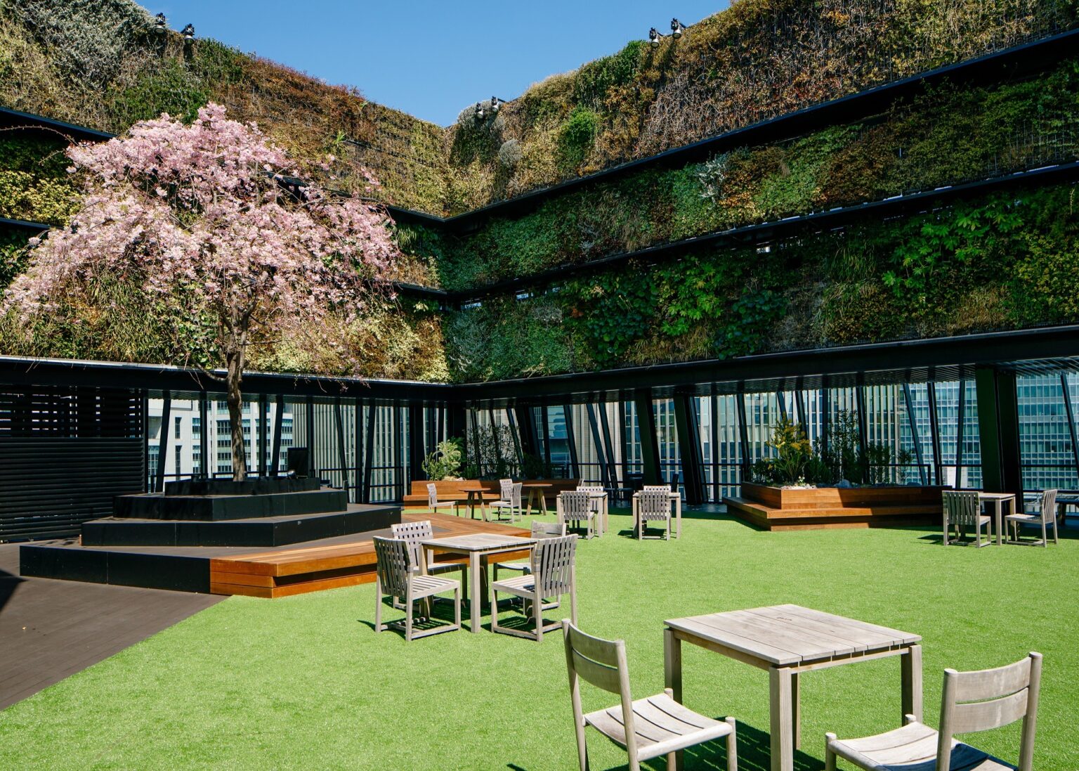 鮮やかなグリーンウォールや春には桜が目を喜ばせる〈グリーンサイド〉は、広々とした空間にテーブルやチェアが配された開放的なスペースです。