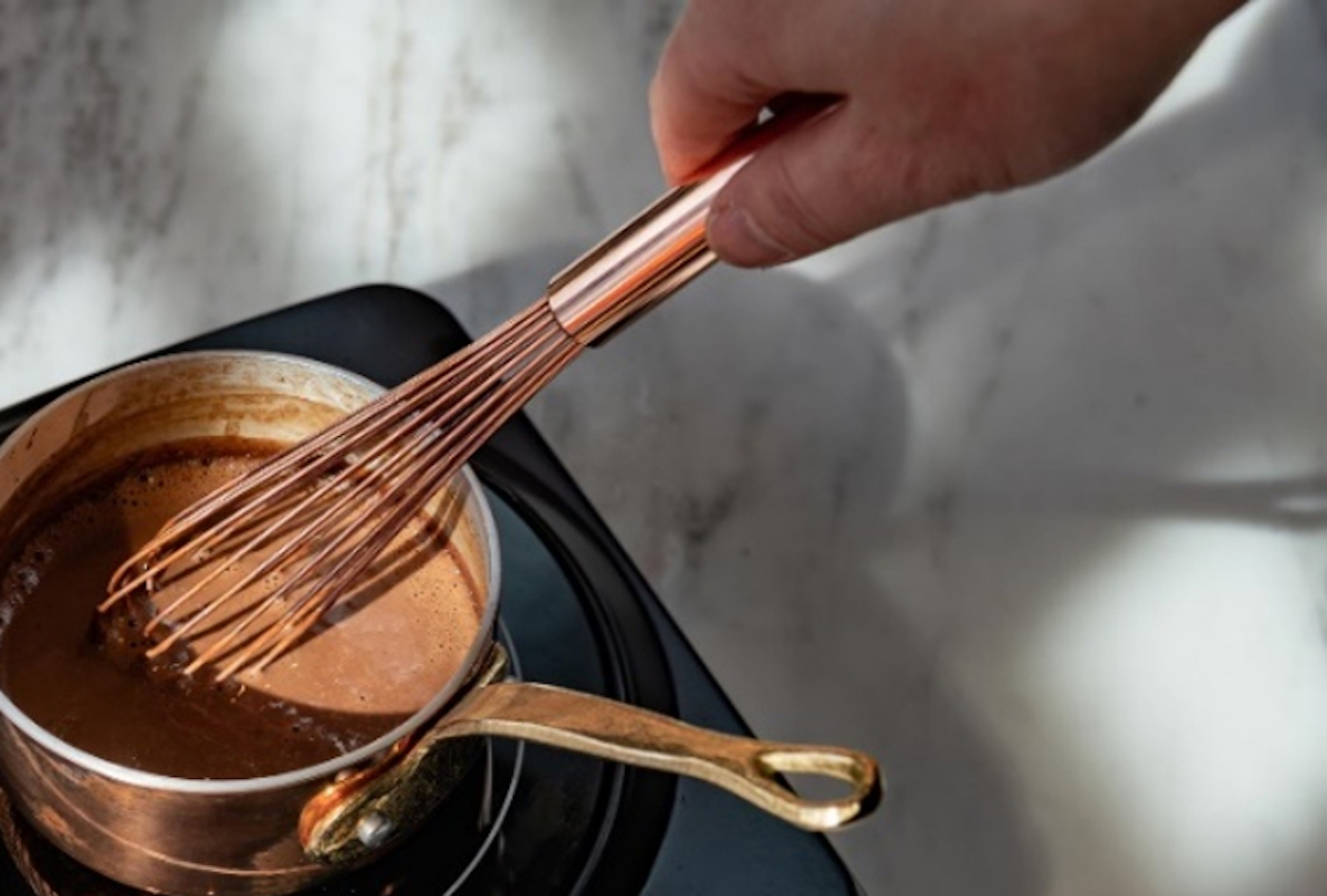 ホットチョコレートの作り方は、まず、小鍋に牛乳を入れ、泡立て器で混ぜながら温める。淵がふつふつとなるくまらいまで温めたら、クラムを加え、泡立て器でよくかき混ぜる。