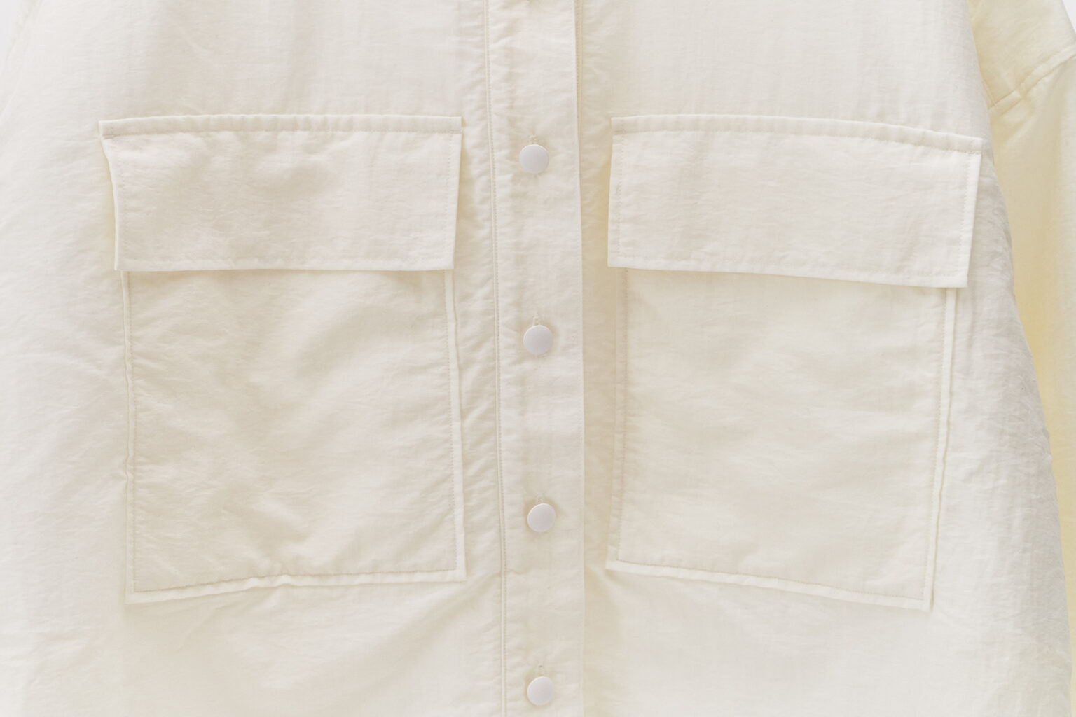 大きなポケットが胸のシルエットを隠してくれる。ボタンは間隔を狭めに配置し、安心感のあるデザインに。