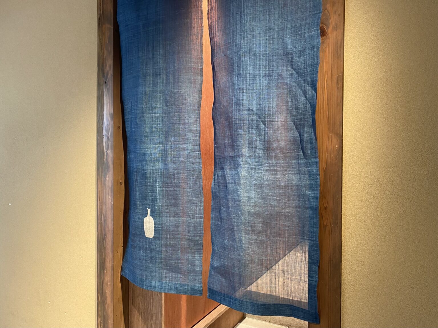京町家と調和する藍染の暖簾。靴を脱いでラウンジへどうぞ。