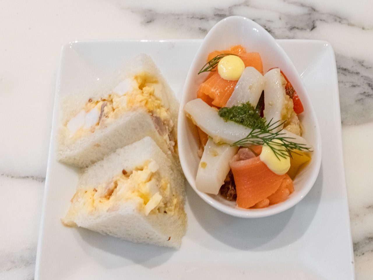 左から「無塩せきロースハムとエッグのサンドウィッチ」、「スモークサーモンと季節野菜のギリシャ風のマリネ」と「小烏賊のマリネ バジルタプナード風味」。