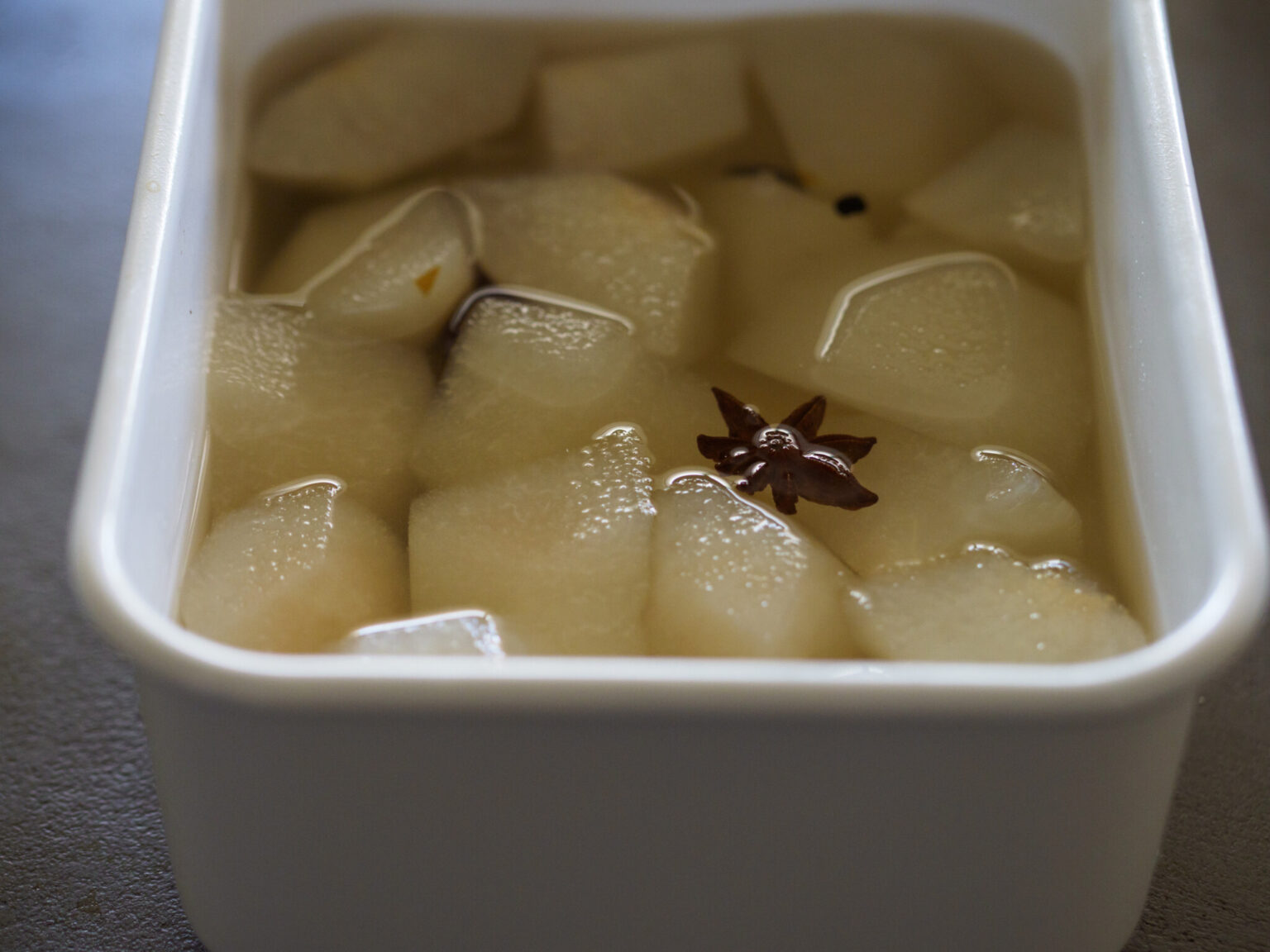 八角、黒コショウ、クローブ、シナモンの入ったシロップに梨を漬けて冷蔵庫で冷やす。