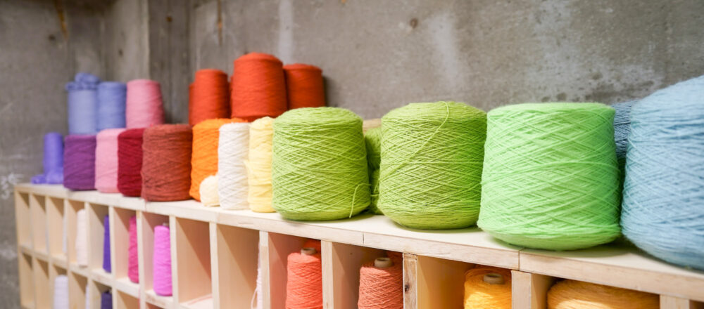スタジオに入ると、ずらりと並ぶカラフルな毛糸たち。これらはインテリアに馴染むカラーをセレクトしワークショップ用に染色した糸。インテリアに馴染むようなカラーを中心に約80種類ほどの糸をセレクト。