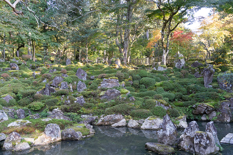 池の向こうの斜面に本堂の仏像に見立てられた19の石が置かれています。