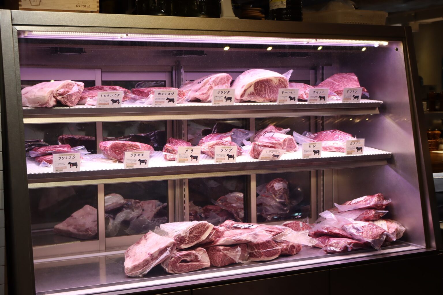 〈エイジング・ビーフ〉にはステーキ店〈グリルドエイジング・ビーフ〉も隣接。エレベーターを降りてすぐに見えるガラスケースには熟成肉がずらり。