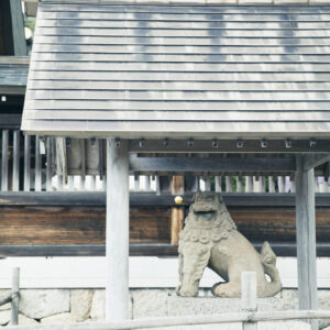 屋根に守られた狛犬は鎌倉時代に作られた石造りで、魔除けの力があると伝わる。どことなく愛らしい表情で、模した土鈴もある。