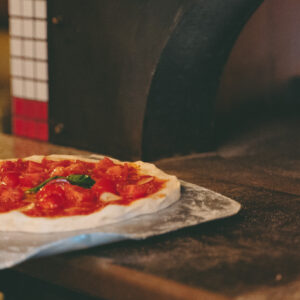 自慢のピザ窯で一気に焼き上げ！みるみる縁が膨らんでいく様子を見るのが楽しい！