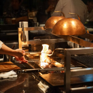 ミシュラン3ツ星の日本料理店〈かんだ〉の神田裕行氏が監修したメニューを提供する〈シラチカ 炉端〉。臨場感溢れるカウンター席での食事は、より一層料理をおいしくする。