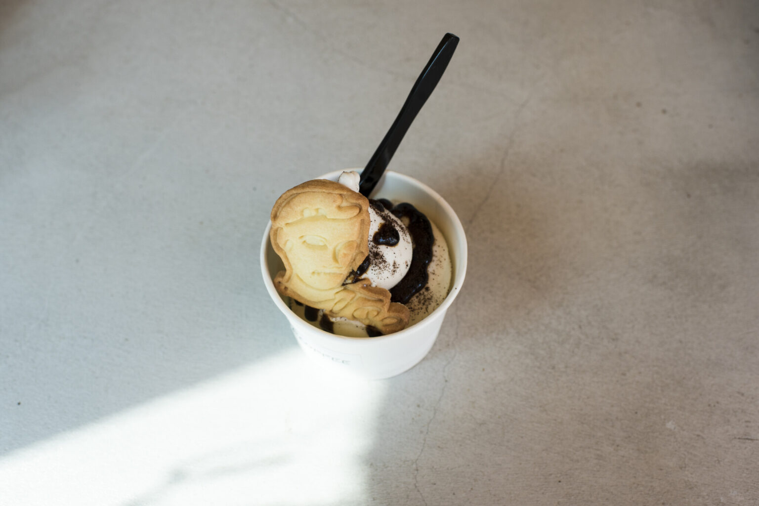 アーモンドミルクのソフトクリーム オリジナルコーヒーソース680円。店のロゴにもなっているキャラクター「ジョー」型クッキーも好評。