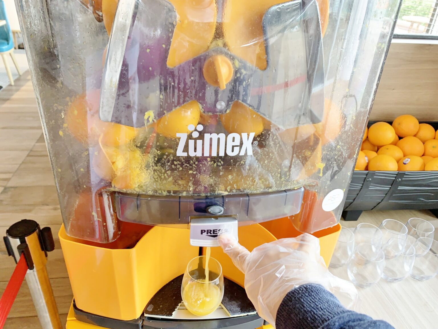 スイッチを押すと、機械が動き出してオレンジをギュッ！絞りたてのオレンジジュースが味わえる。