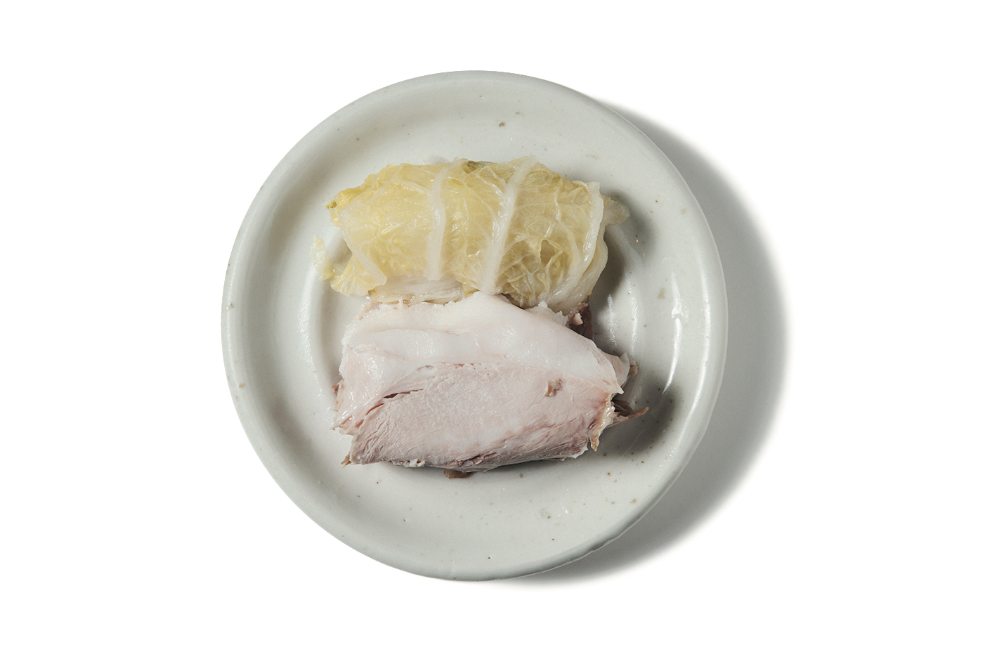 蒸し豚と塩漬け白菜600円。蒸した豚の薄切り肉を塩漬けした白菜で巻いた、韓国の家庭料理。白菜に1枚ずつ豚肉をのせ、ニンニク入りの醤油をつけていただくスタイル。韓国人が懐かしむ昔ながらの味。