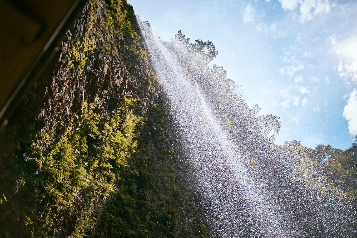 雄滝はオーバーハングになっており、水しぶき越しに青空をのぞめる。
