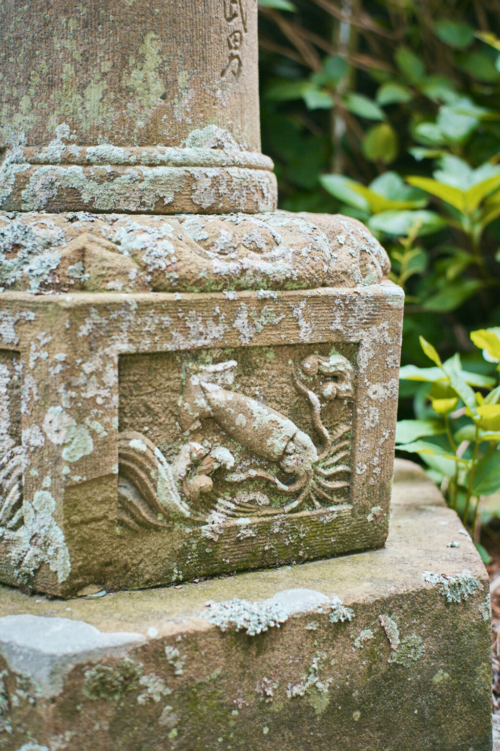 石灯籠に彫られた波に遊ぶイカ。拝殿の装飾にもイカの姿が見られる。