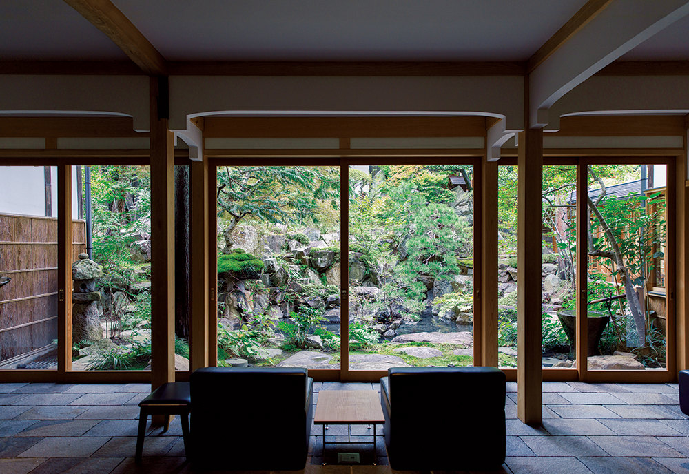 畳敷きの大広間はラウンジへと生まれ変わり、創業時の姿を残す中庭を望む。家具デザインは、松本の木工作家・前田大作。