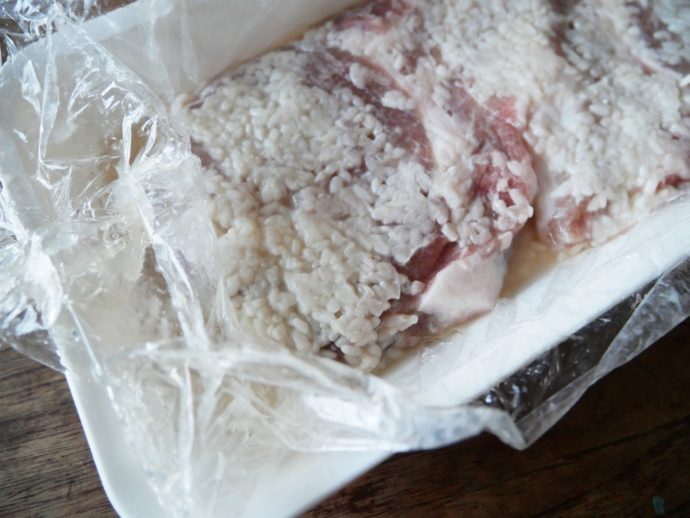 豚のリブロースの塩麹漬け。ラップに包んでしっかりと肉に旨味を染み込ませます。