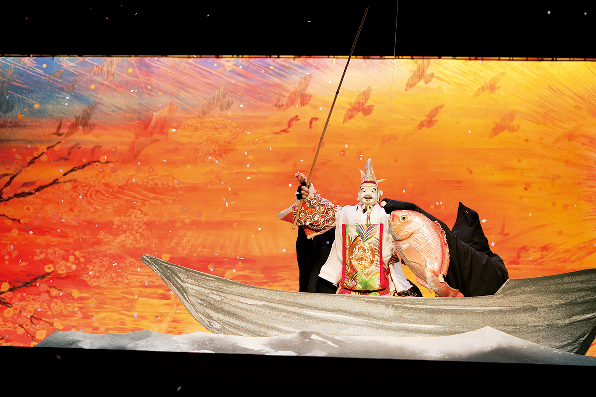 淡路島の朝日を描いた清川あさみさんの大作「inori」が背景に出現。戎様が鯛を釣り上げ、めでたく舞い納める『戎舞＋（プラス）』のクライマックスは圧巻。