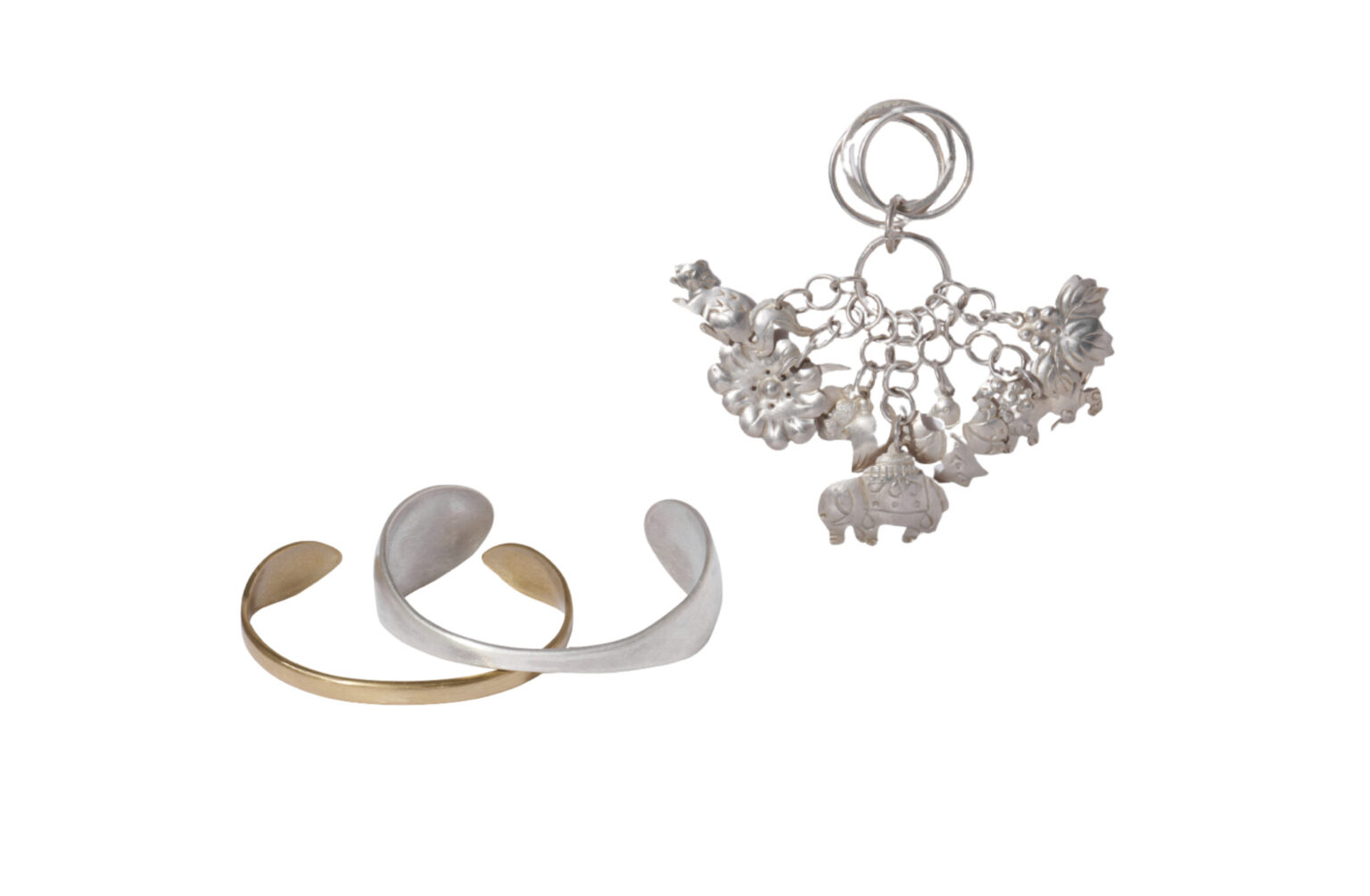 〈cicafu metal works〉の装身具。喜舎場智子と平澤尚子の二人で制作。左は真鍮とシルバーの「Wrap bracelet」。右は、伝統装飾品をアレンジした「オリジナル房指輪」。シーサーや鳩などの繊細なモチーフが魅力。展示会や問い合わせにて販売。