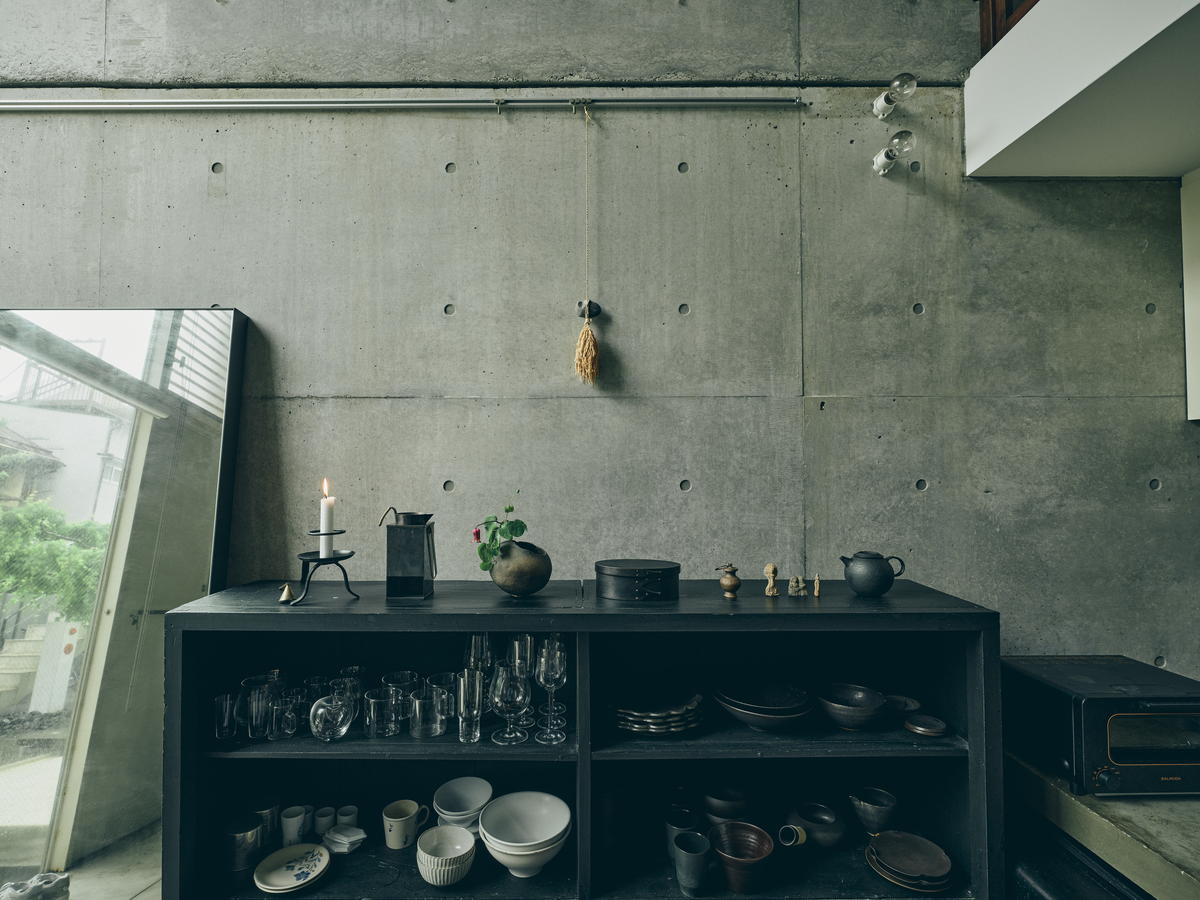 黒く塗装された古い食器棚。壁の稲穂と石の飾りは〈榊麻美植物研究所〉作。