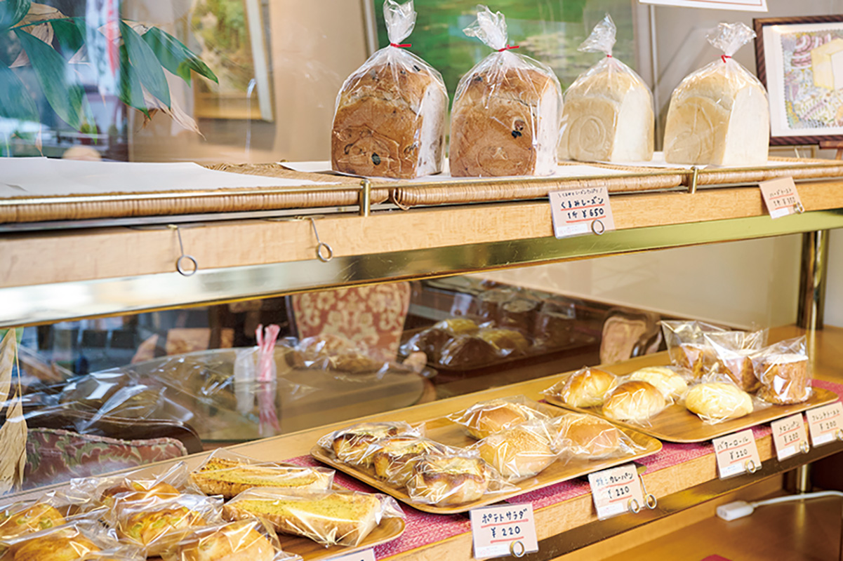 店の入口にはベーカリーコーナーも。食パン1斤350円～のほか、ミックスサンド300円などの惣菜パンもある。