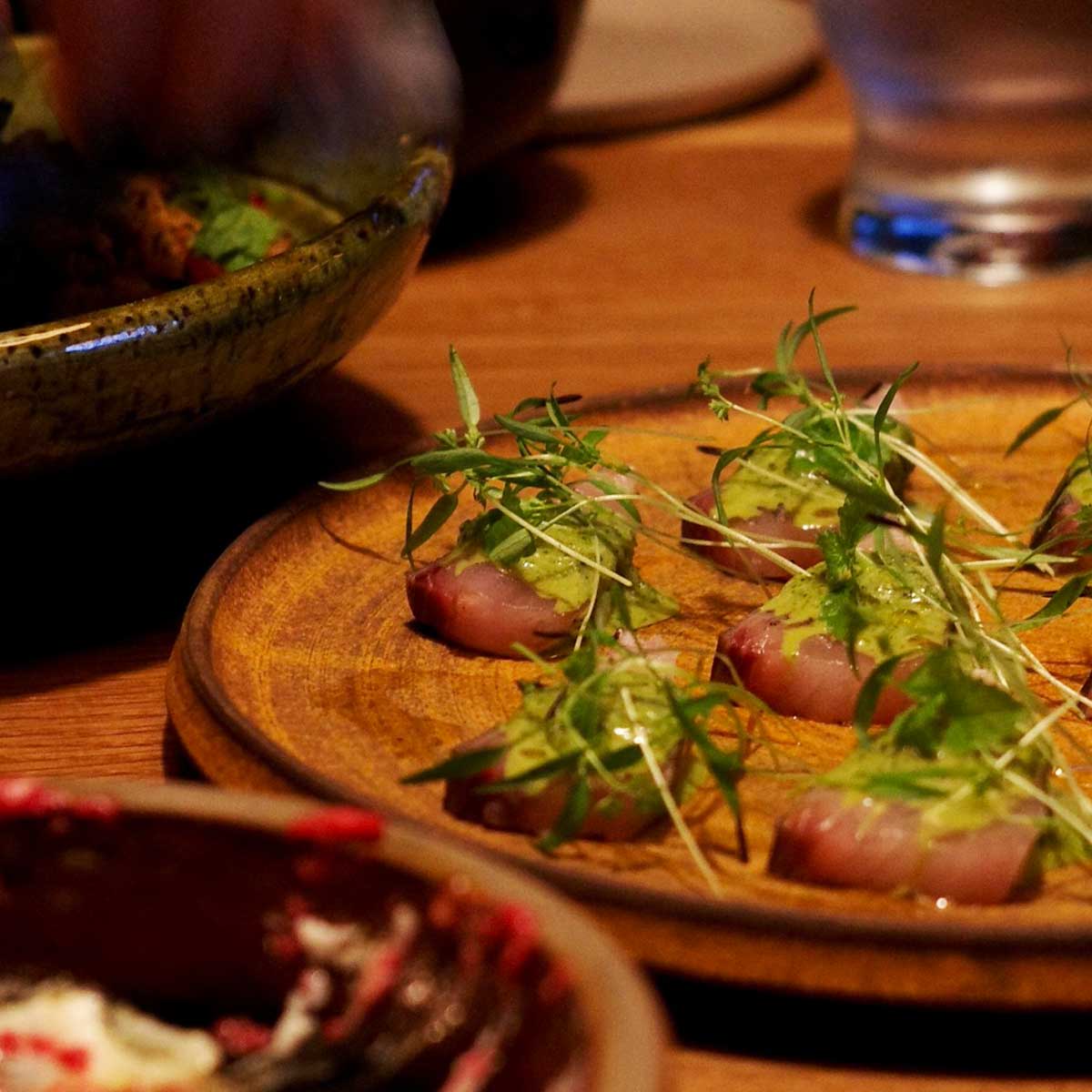 《戌亥 INUI》のスパイスの効いたシェアスタイルの大皿料理。