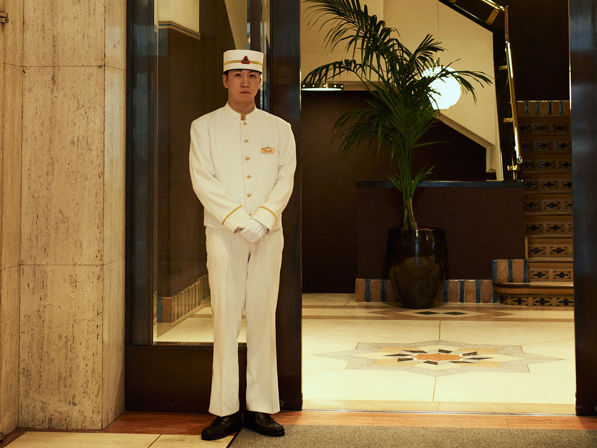 ホテルマンのクラシックな制服と佇まいがホテルのレトロな雰囲気を引き立てます。