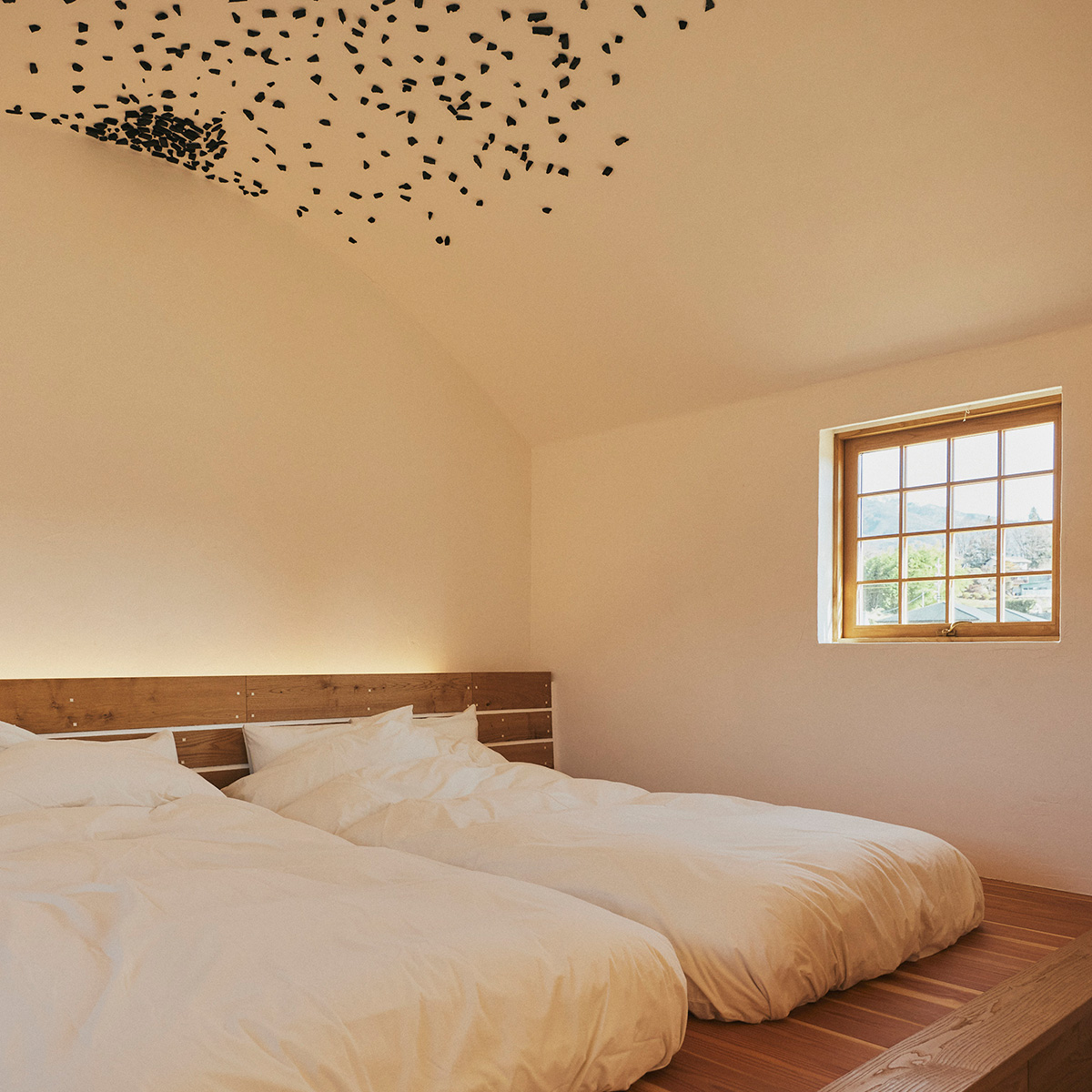 藤森建築の特徴のひとつ、漆喰の天井に炭を張る意匠はベッドルームで見ることができる。