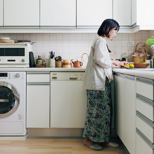 白を基調としたL字型キッチン。「備え付けの食洗機と洗濯乾燥機が白なので、電子レンジや冷蔵庫も揃えて白いものに。色数を増やさないだけですっきり見えます」