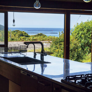 LDKの南側は、全面が窓。「海を見ながら料理ができて幸せ」という。キッチン下にはヒバのチップを使い、湿気対策も万全にするなど実用面にも配慮している。